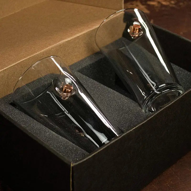 Two champagne flutes in a black foam box with a BenShot Pint Glass
