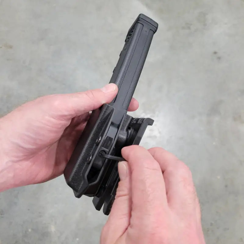 Black Sig Sauer MPX magazine holster being adjusted for optimal fit and comfort