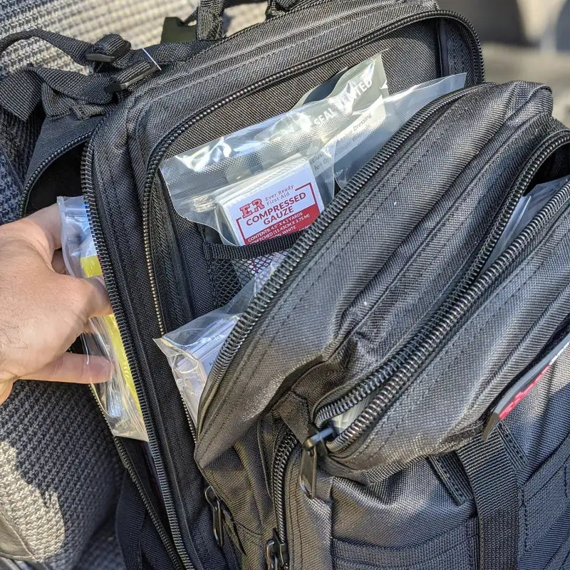 Black tactical backpack for tactical trauma kit and trauma kit storage