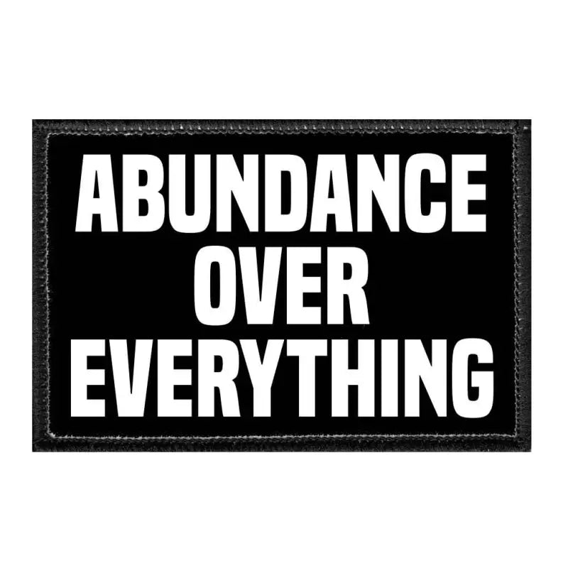 Black and white removable patch with Abundance Over Everything on velcro loop surface