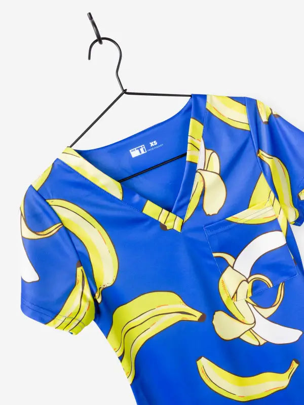 Blue bananas scrub top with yellow banana print on a hanger for first responders