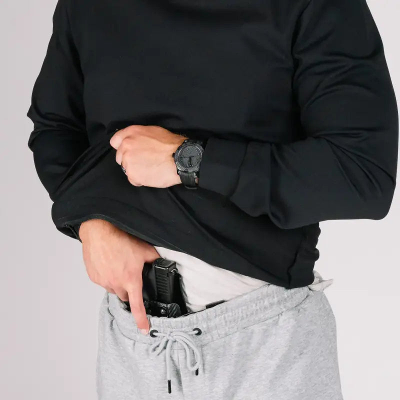 Concealed handgun in sweatpants pocket of durable concealment hoodie with smooth draws