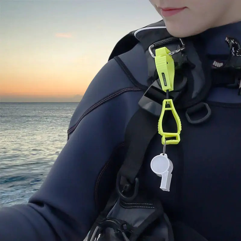 Diver safety whistle attached to Glove Clip Safety Holder for secure storage and access
