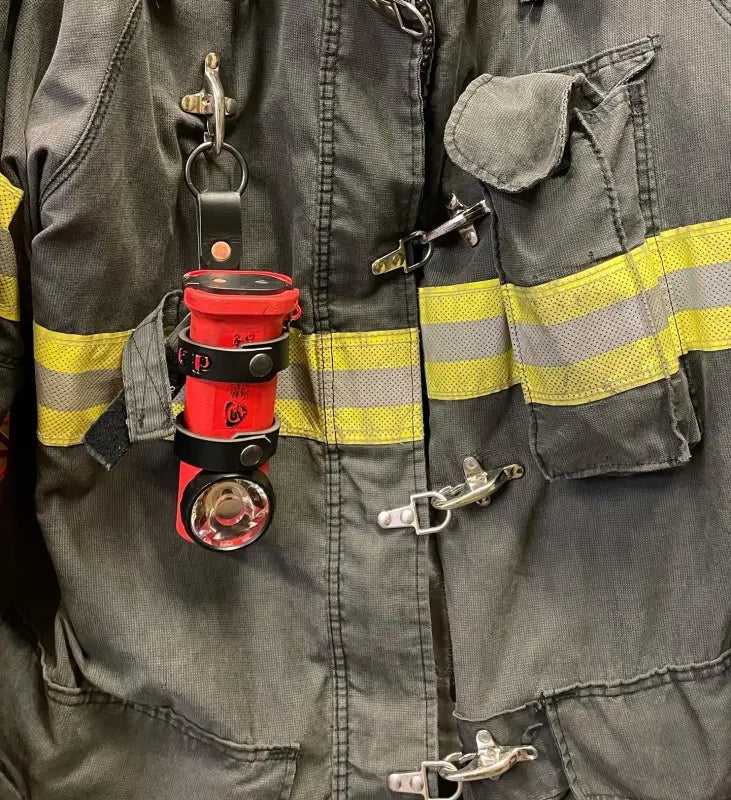Firefighter’s turnout coat with attached inverted firefighter flashlight holder for added safety