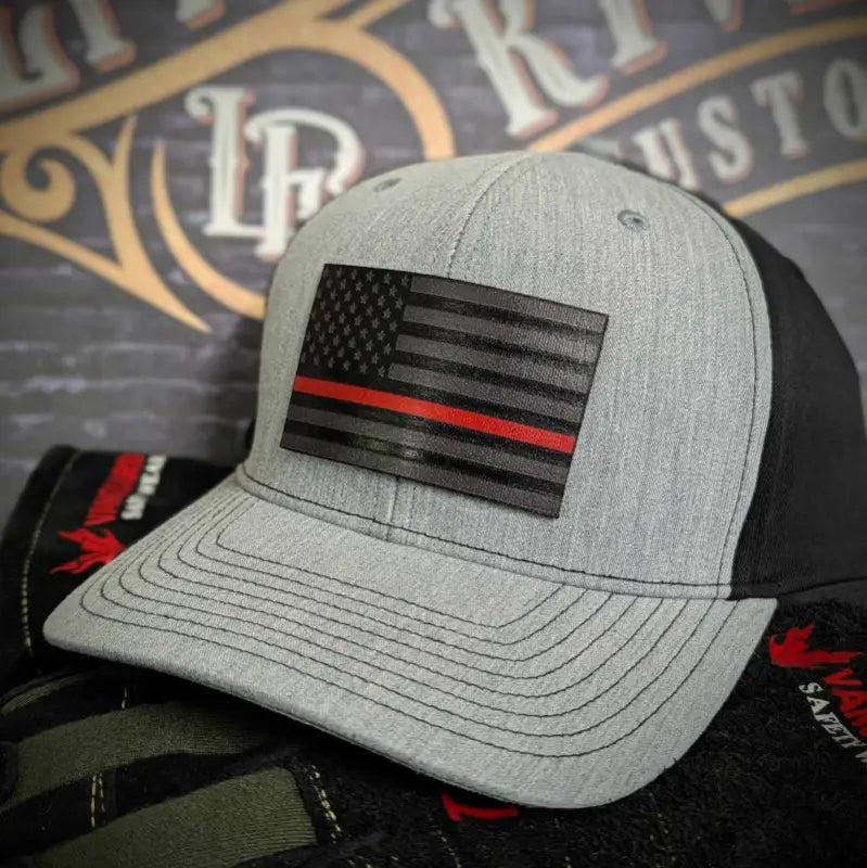 Gray and black baseball cap with a red line leather patch featuring a thin red line flag