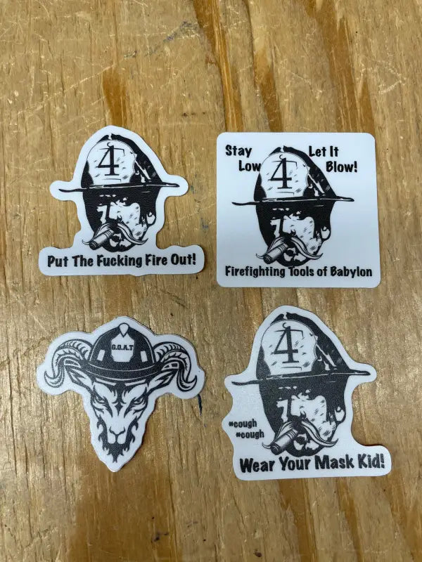 Four firefighter helmet stickers featuring slogans on a wooden surface