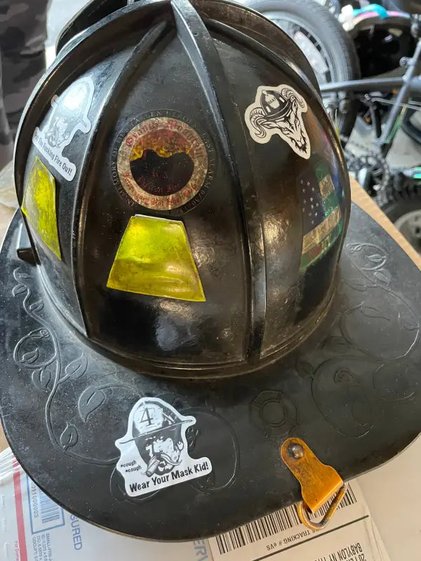 Black firefighter helmet adorned with vibrant helmet stickers for first responders