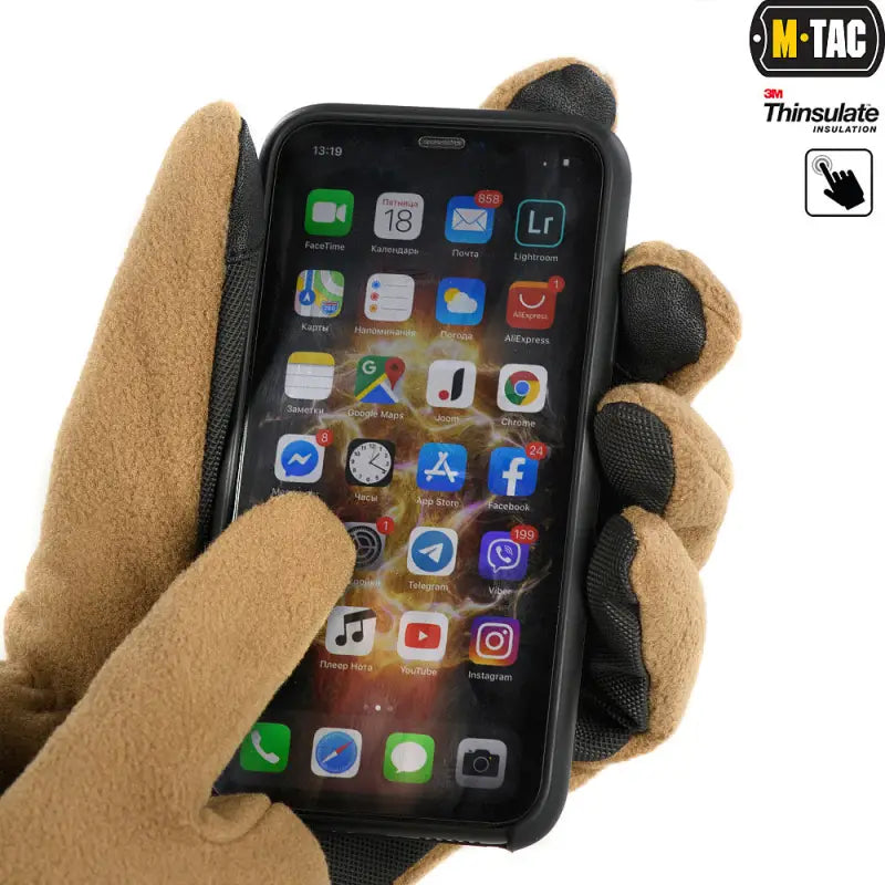 Tan tactical glove using an iPhone, showcasing M-Tac Gloves Fleece Thinsulate features