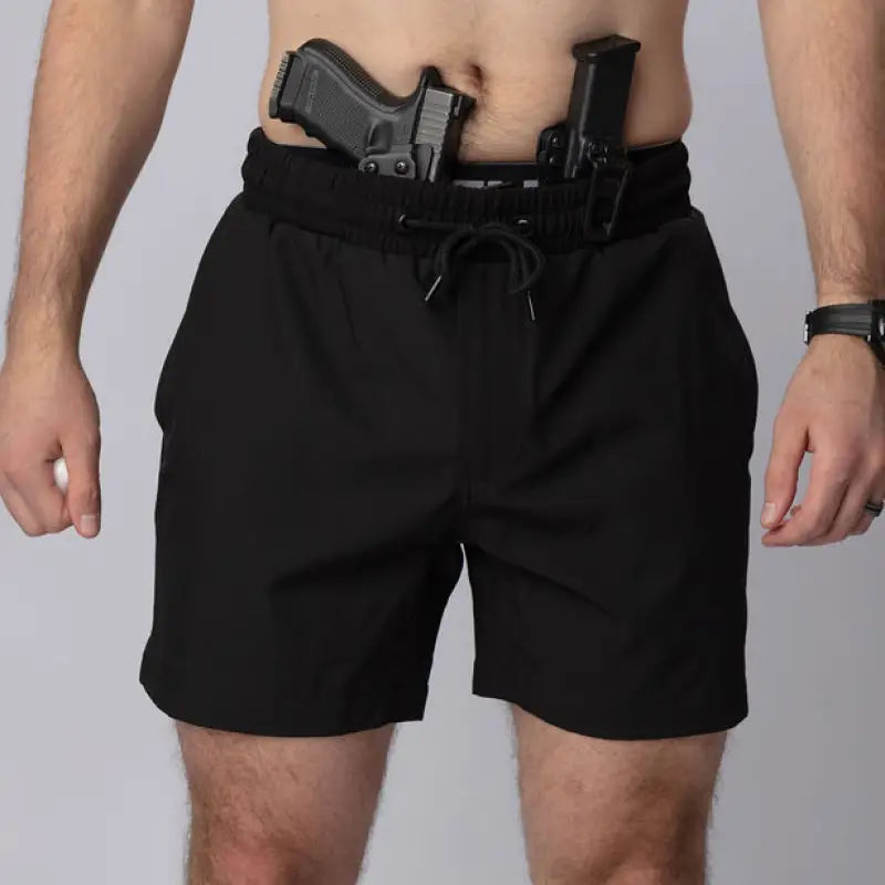 Man wearing Carrier Training Shorts Mk.II with concealed carry and two handguns