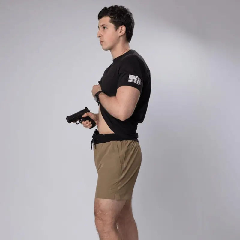 Man holding handgun in Carrier Training Shorts Mk.II for concealed carry and training