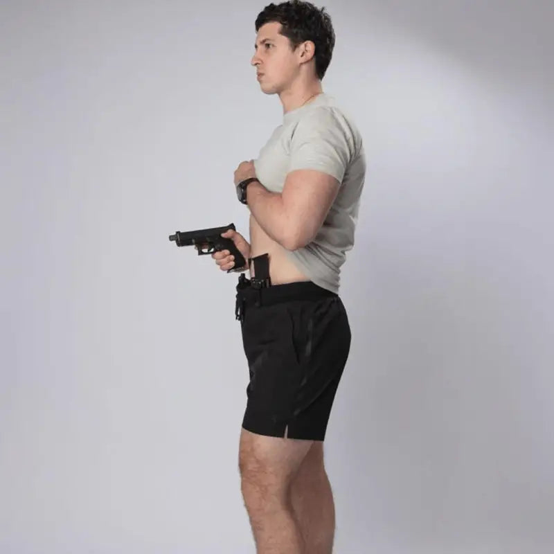 Man holding a handgun wearing Carrier Training Shorts Mk.II for concealed carry