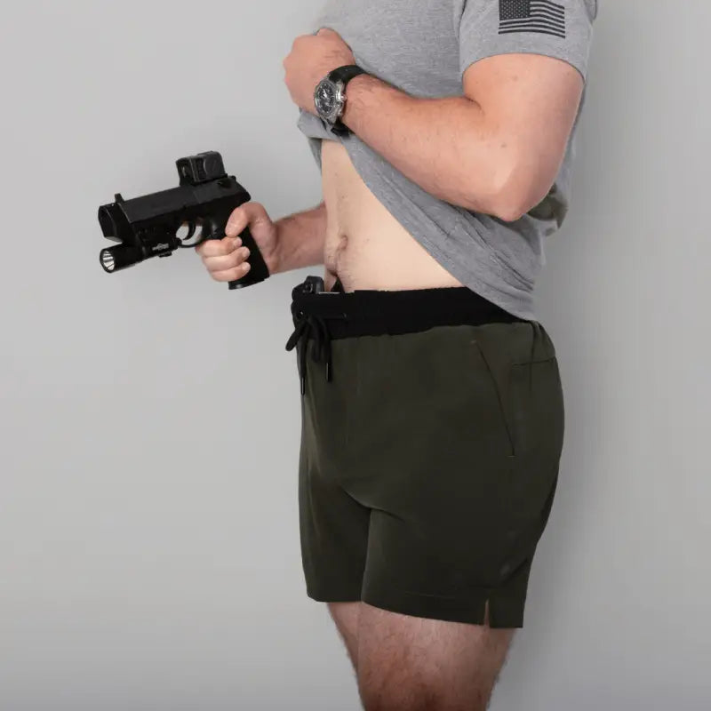 Man holding a handgun in Carrier Training Shorts Mk.II for concealed carry training