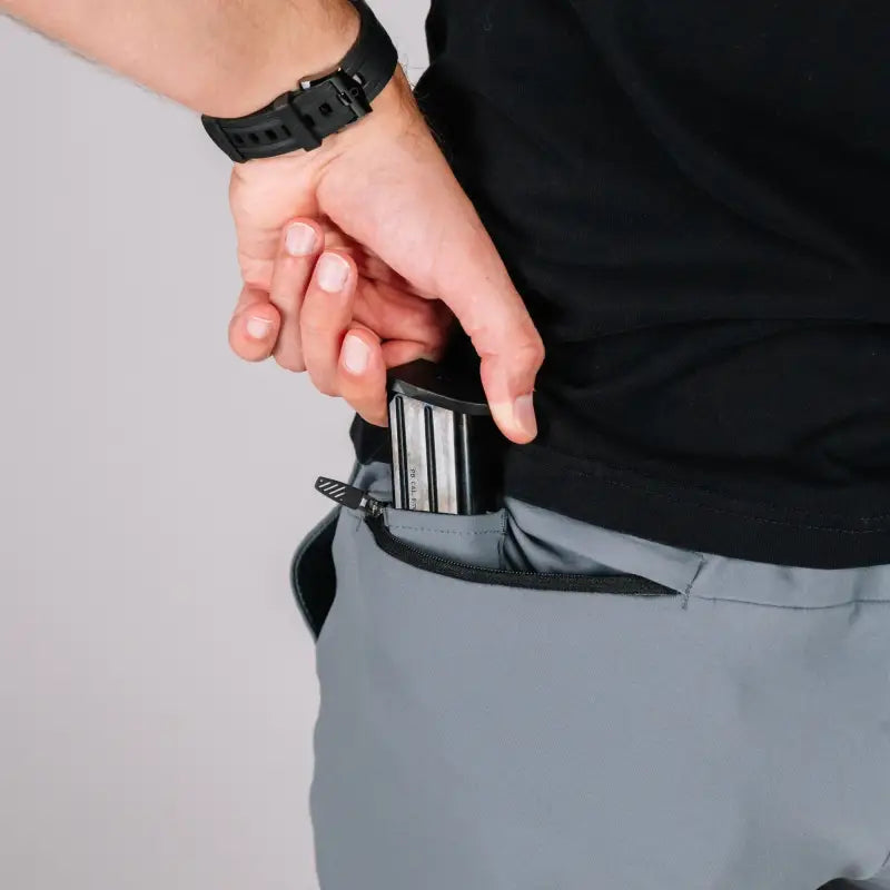 Man inserting magazine into pocket of Carrier Shorts Mk.II for concealed carry by Arrowhead Tactical Apparel