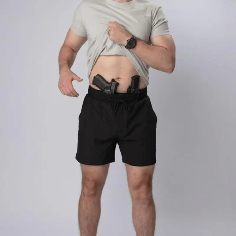 Man with two guns in waistband wearing Carrier Training Shorts Mk.II for concealed carry