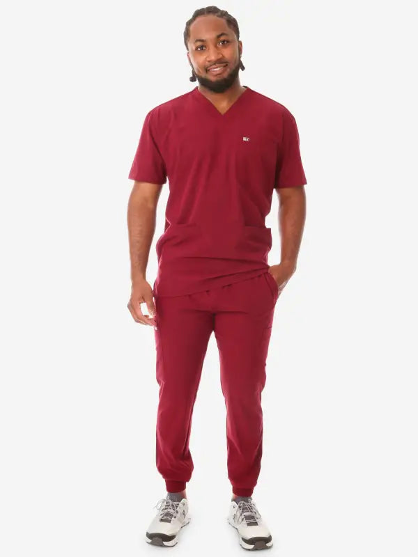 Burgundy men’s five-pocket scrub set paired with gray sneakers for a stylish look