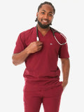 Healthcare worker in burgundy scrubs featuring a stethoscope and men’s five-pocket design