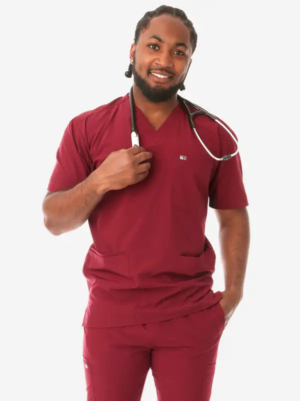 Healthcare worker in burgundy scrubs featuring a stethoscope and men’s five-pocket design