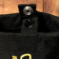 Black canvas firefighter rescue tool with metal snap fastener and yellow embroidered detail