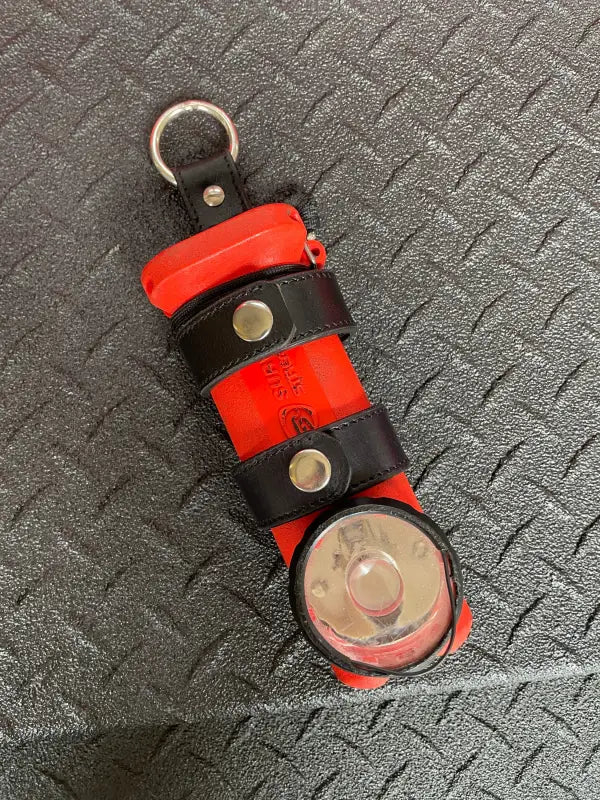 Red flashlight with black leather straps in THE MINIMALIST Leather Inverted Flashlight Holder