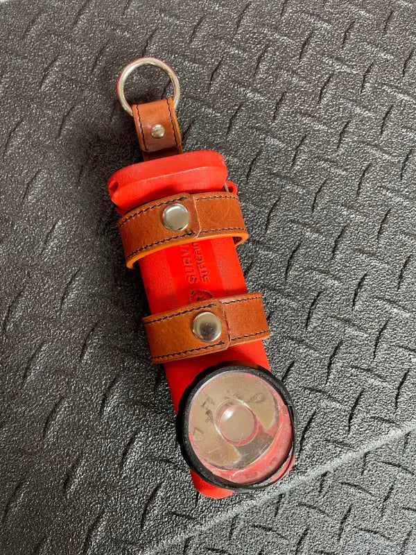 Red survival signal flare with leather straps in THE MINIMALIST Leather Inverted Flashlight Holder