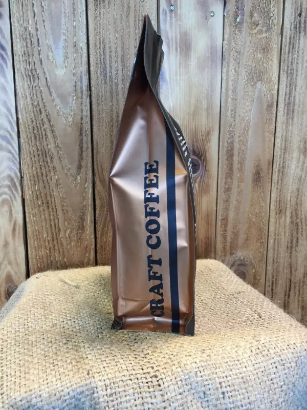 Stand-up pouch of Cinnamon Rum Pecan Flavored Coffee in metallic bronze packaging