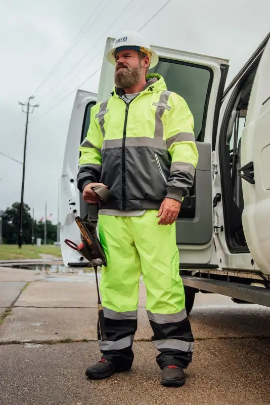 Worker in high-visibility gear by vehicle wearing UHV823 Hi-Vis Utility Rain Pants