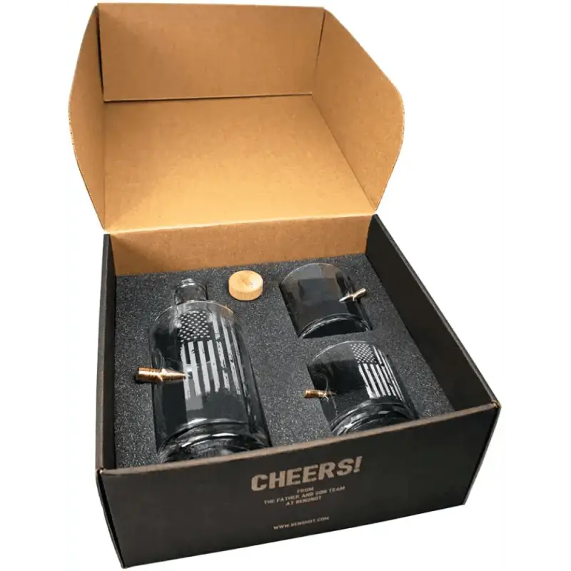 Black gift box with whiskey decanter, rocks glasses, and bar accessories in foam padding