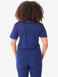 Back view of navy blue women’s four-pocket scrub uniform with visible curly hair