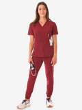 Burgundy women’s four-pocket scrub uniform with v-neck top and jogger-style pants