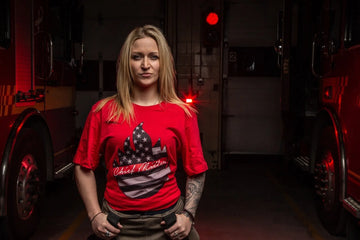 Chief Miller firefighting merch featuring a model in a red tee shirt at a fire station.
