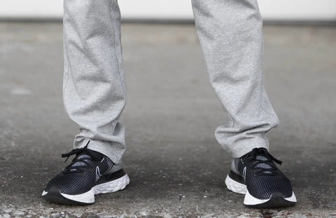 Black and white running shoes paired with NEW Carrier Sweatpants Mk.II featuring patented carrier retention.