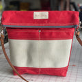 Crossbody Burn Bag in Engine Red made from decommissioned fire hose, showcasing its unique wear and waterproof waxed canvas.