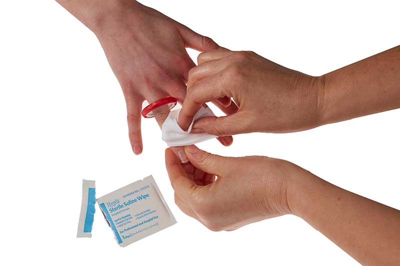 Hand cleaning a finger with a red ring using Finger Cut Kit for proper wound care