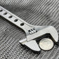 Adjustable metal wrench gripping a quarter, featuring the 8 Inch Titanium Adjustable Wrench