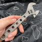 Adjustable wrench held against topographic pattern fabric showcasing 8 Inch Titanium Adjustable Wrench