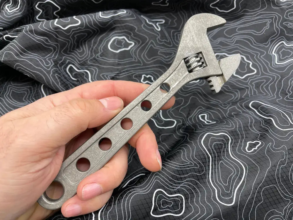 Adjustable wrench held against topographic pattern fabric showcasing 8 Inch Titanium Adjustable Wrench