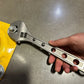 Adjustable titanium wrench held over a vibrant yellow surface showcasing corrosion resistance