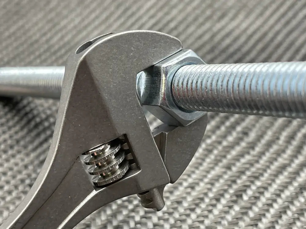 Adjustable Wrench gripping a metal bolt - Titanium 6 Inch NSN Pending product image