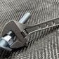 Adjustable Wrench gripping a metal bolt for precise fastening, NSN Pending, Titanium 6 Inch