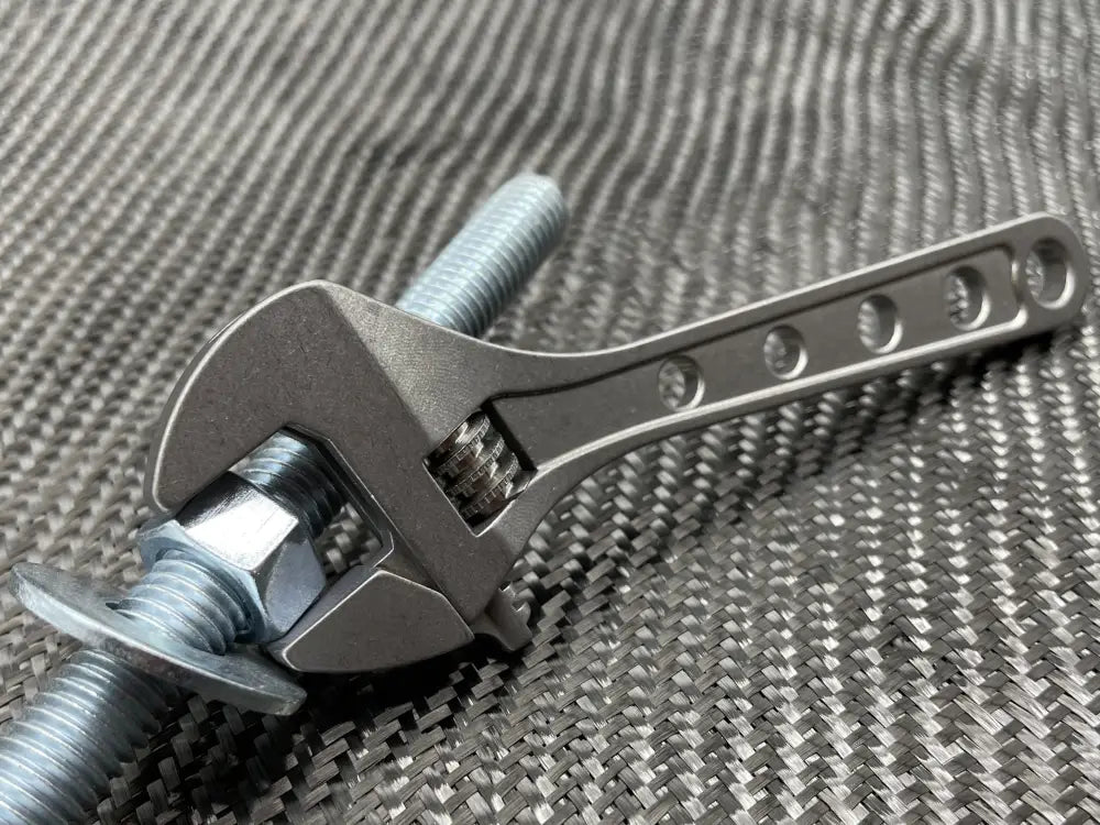 Adjustable Wrench gripping a metal bolt for precise fastening, NSN Pending, Titanium 6 Inch