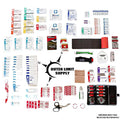 First aid kit with rolled gauze and elastic patch bandages near compass logo