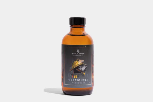 Amber glass bottle with black cap and firefighter aftershave label featuring red cedarwood