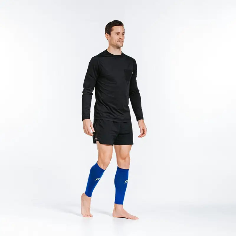 Athletic calf compression sleeves in royal blue worn with black workout attire