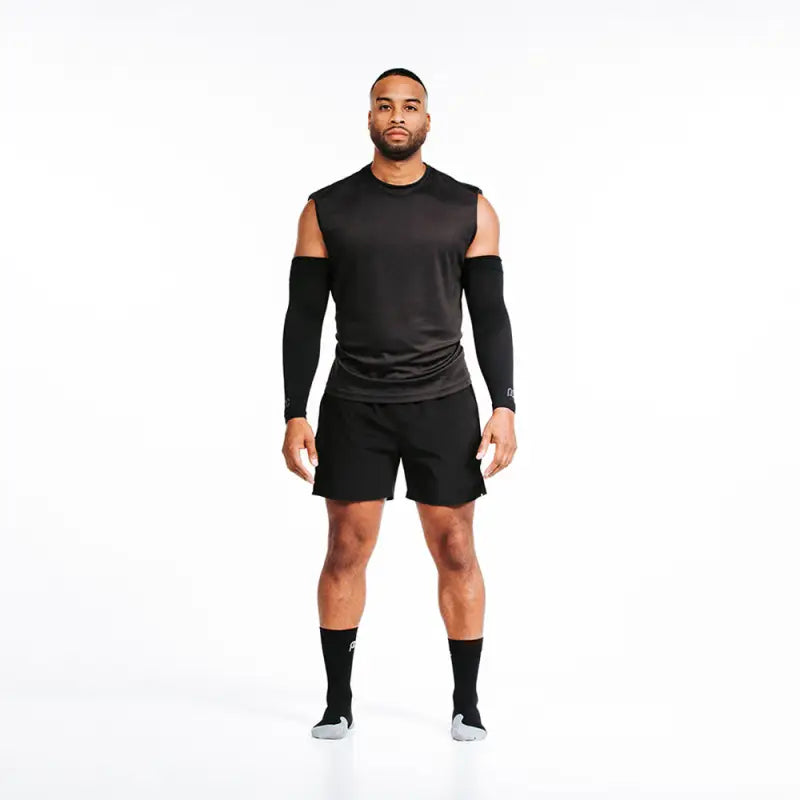 Athletic figure in all-black workout attire featuring Arm Sleeves for optimal performance