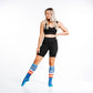 Athletic figure in black sports bra and biker shorts with colorful socks for Colorado Peaks