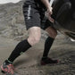 Athletic legs in Tall Compression Socks, shorts, and trail running shoes for long distance courses