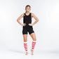 Athletic person in black gear showcasing Compression Calf Sleeves with red-and-white stripes