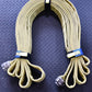 Beige fire hose in loops secured with blue individual hose strap and rectangle metal ring