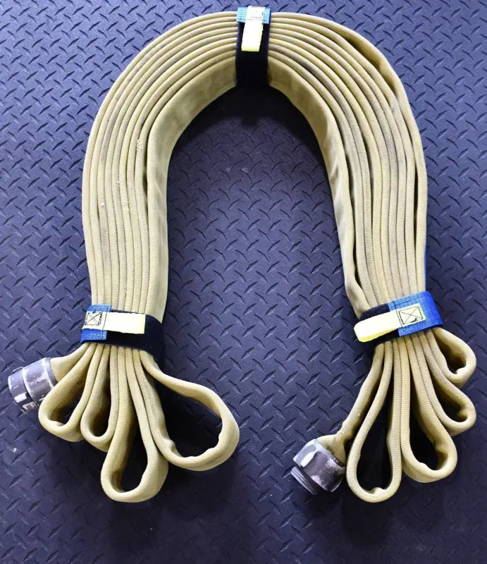 Beige fire hose in loops secured with blue individual hose strap and rectangle metal ring