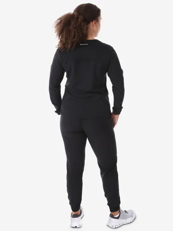 Black athletic jumpsuit with long sleeves and tapered legs for women’s long-sleeve scrub